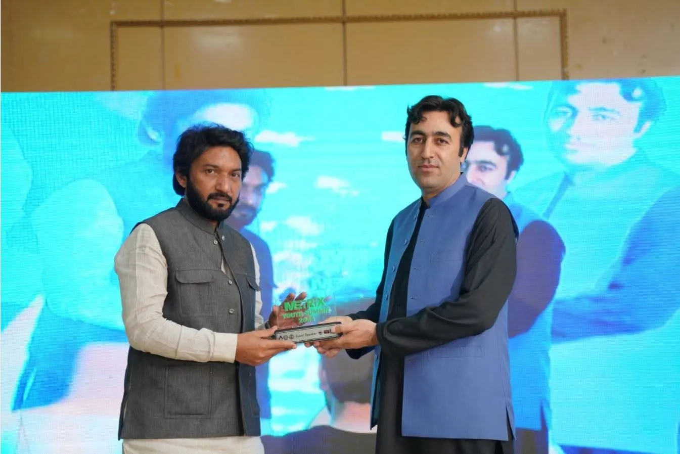 Qaiser Akash Khan receiving the Pride of KP and Guest Speaker award from Mr. Humayun Khan on stage at the Metrix Pakistan event at the University of Malakand.